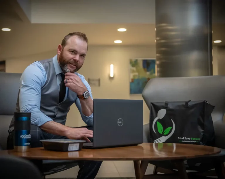 Busy professional working with Meal Prep Sunday prepared meal bag at his side