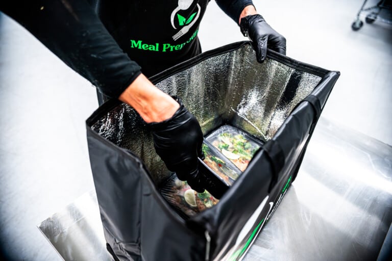 Meal Prep Sunday team packaging fresh, macro-balanced prepared meals for weekly delivery