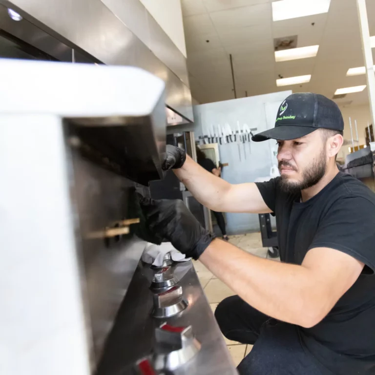 Employee sanitizing kitchen surfaces for safe, hygienic meal preparation