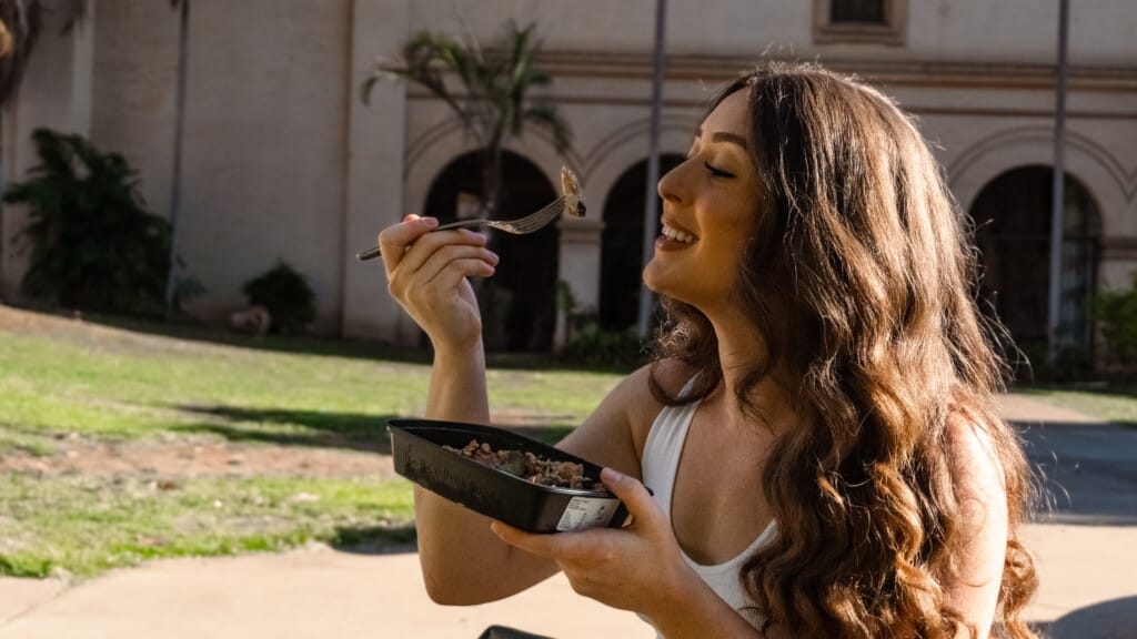 Influencer eating Meal Prep Sunday meal while sharing video testimonial experience