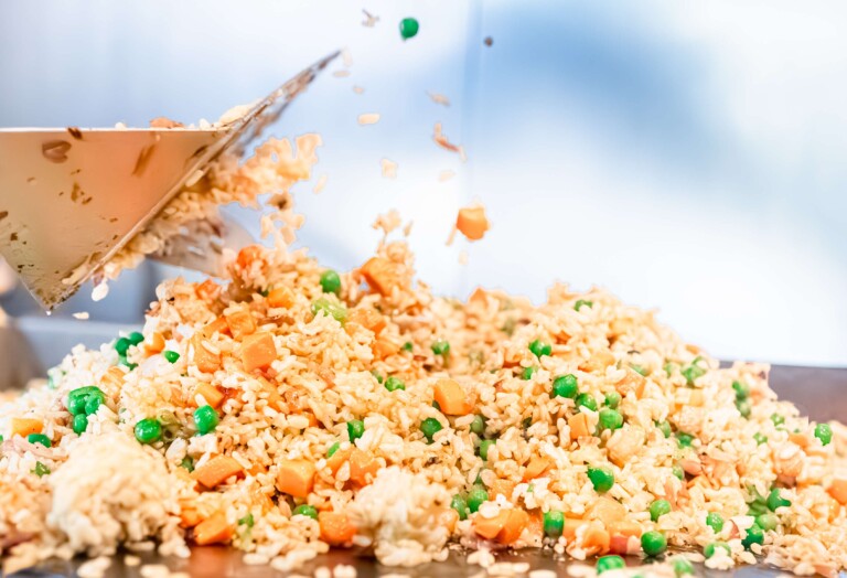 Jasmine rice being prepared with onions and chicken stock.