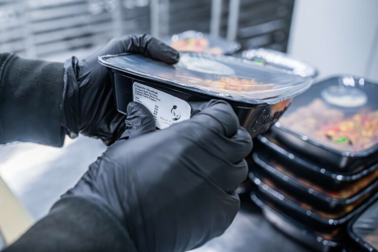 Chef storing 7-day meal prep in cold storage to maintain freshness