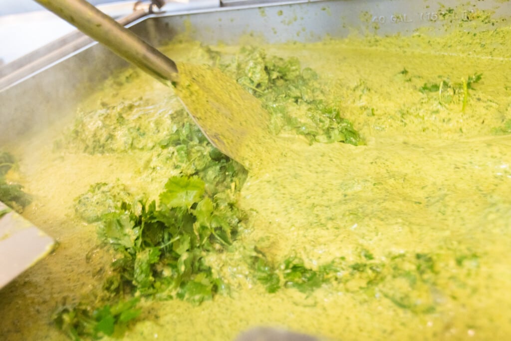 Habanero chunky salsa being blended with fresh herbs and vegetables for sweet heat chicken meal prep