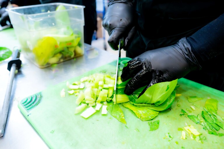 Chef chopping fresh organic greens for farm fresh meal prep.