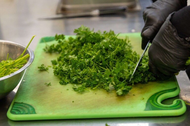 Fresh cilantro being cut for how to cook chicken breast recipe.