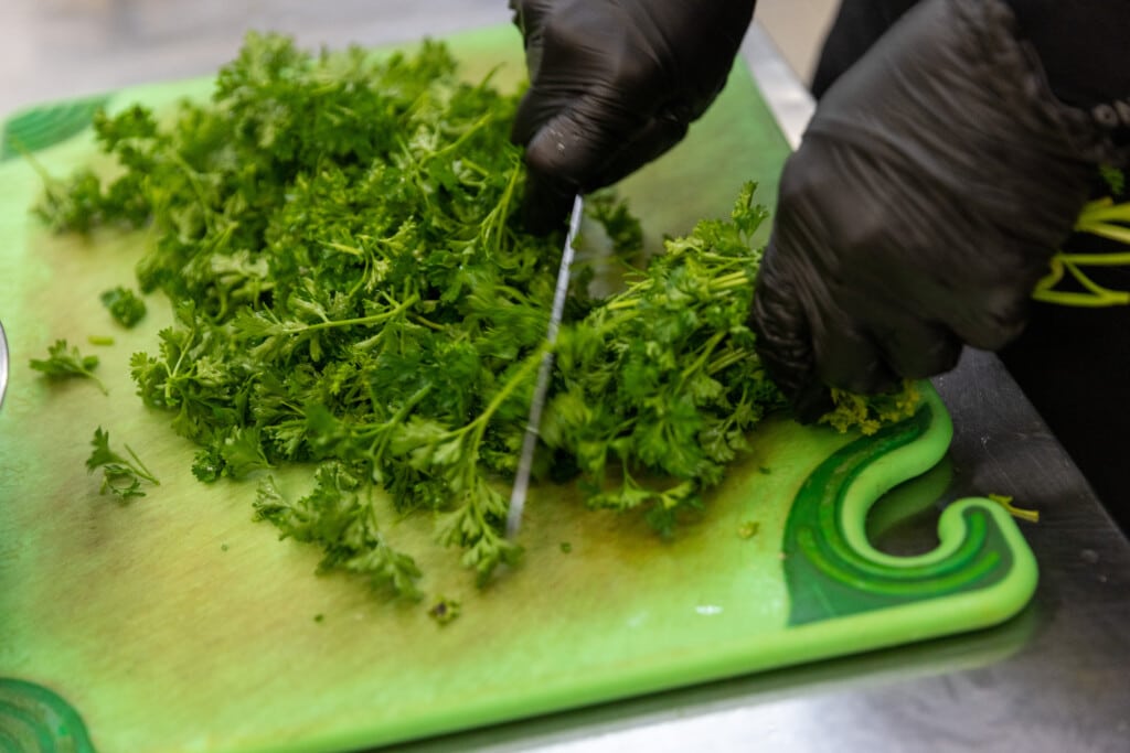 Fresh cilantro being cut for how to cook chicken breast recipe