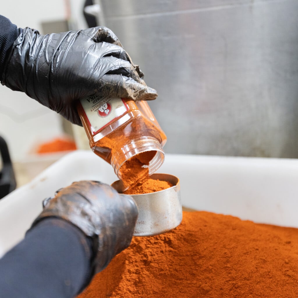 Turmeric-based seasoning being poured