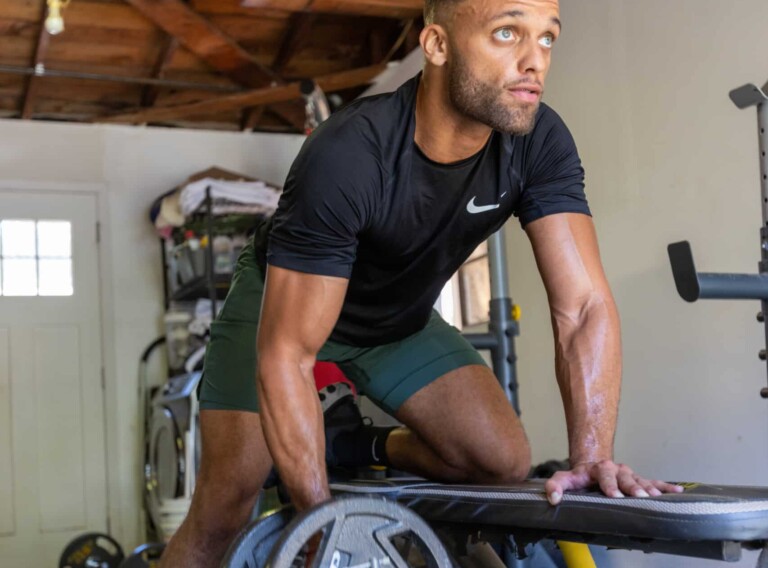Fitness influencer lifting weights as part of strength training routine to hit his fitness goals