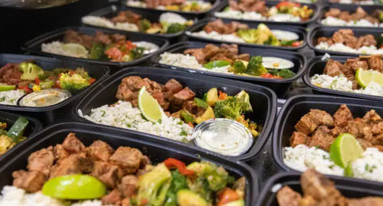 Steak meal prep bowls packed in containers with rice, vegetables, and sauce
