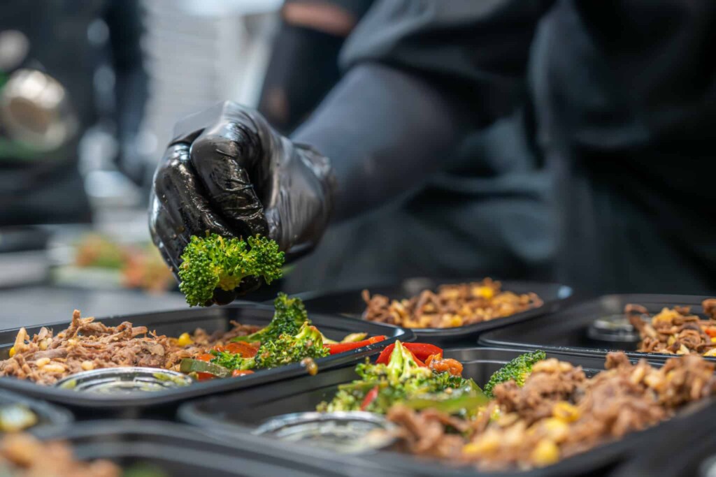 Chef assembling meal components with precision and portion control
