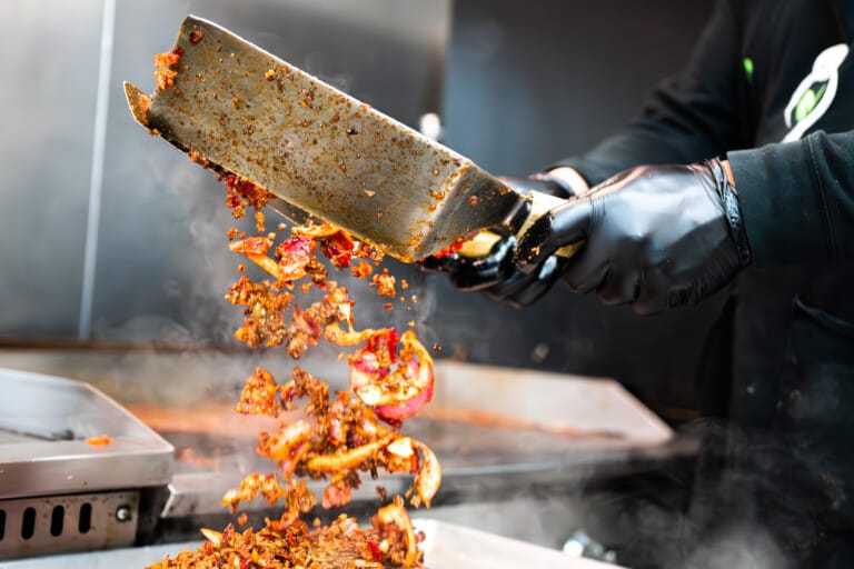 Chef chopping and grilling proteins for nutritious meals