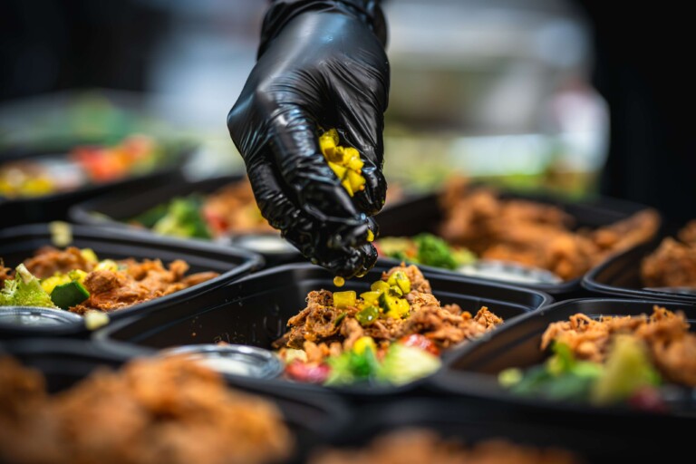 Pouring house-made aioli over spicy herb chicken meal prep.