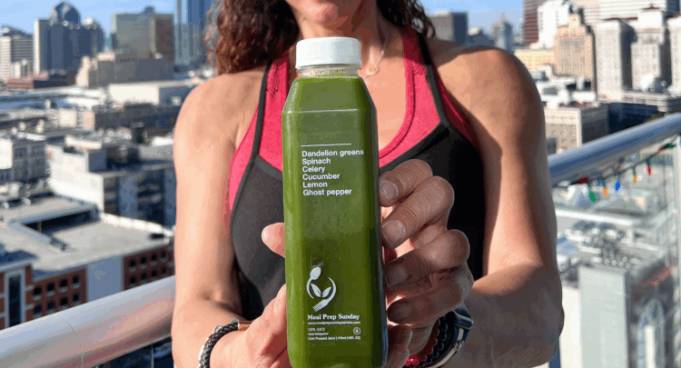 Fitness trainer holding juice from meal prep delivery service in San Diego