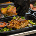 Chef garnishing glazed salmon with edamame and black rice, a best meal delivery service option from Meal Prep Sunday