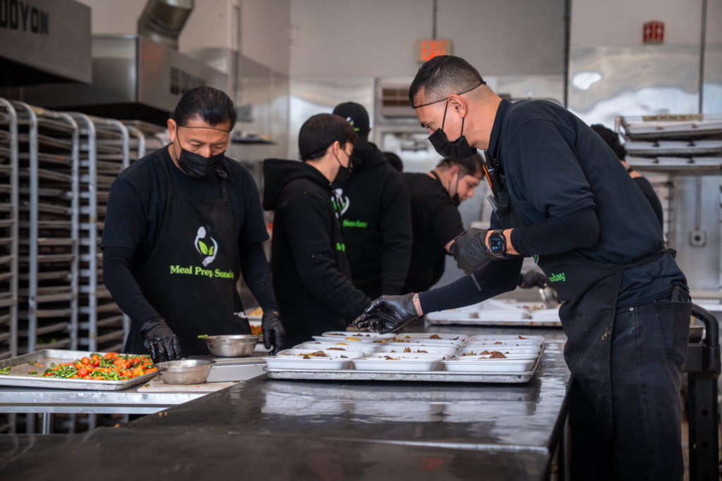 Masked Meal Prep Sunday kitchen staff portioning ingredients for diabetic-friendly meal prep
