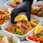 Gluten free meal delivery service guide: chef adding a lemon wedge to a Meal Prep Sunday steak, shrimp, and asparagus meal