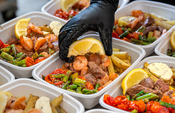 Gluten free meal delivery service guide: chef adding a lemon wedge to a Meal Prep Sunday steak, shrimp, and asparagus meal