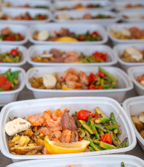 Rows of Meal Prep Sunday ready made meals with shrimp, steak, asparagus, cherry tomatoes, and roasted potatoes